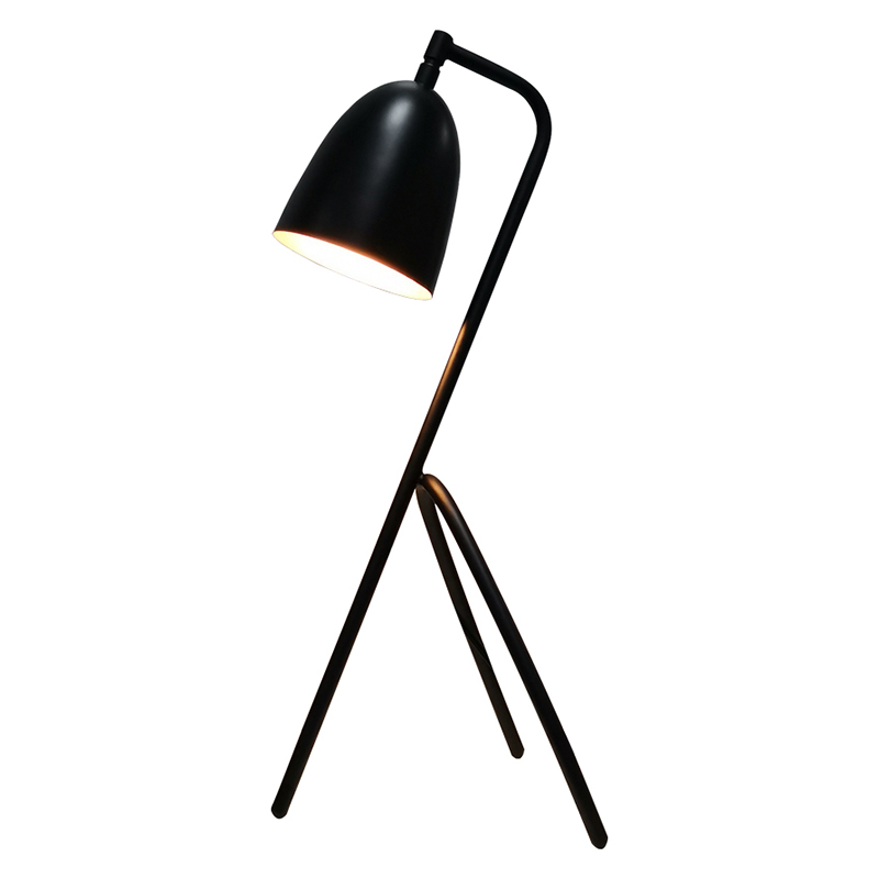 Stolní lampa třinohy s černým povrchem a přepínačem rockeruna linii v pokoji